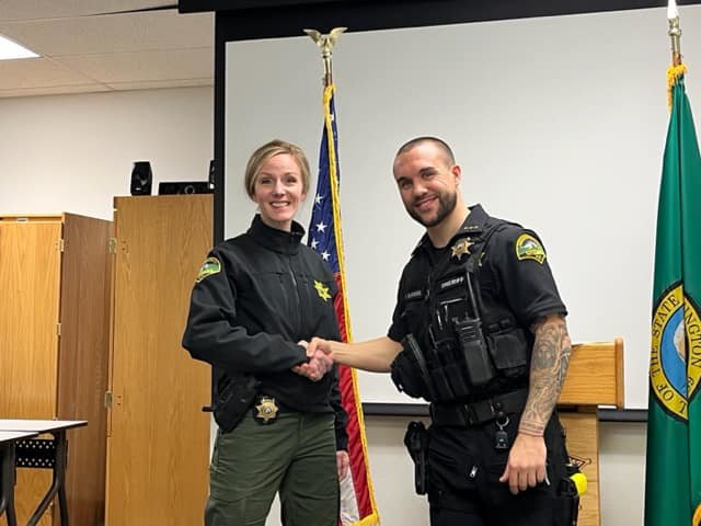 Thurston County Sheriff Derek Sanders shakes the hand of Carla Carter, the new chief of support services, in a photo shared on Facebook Jan. 1.
